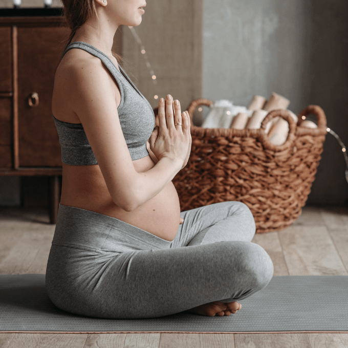 Photo d'une femme enceinte méditant pour illustrer les techniques de calme pour article de blog de spiritual light